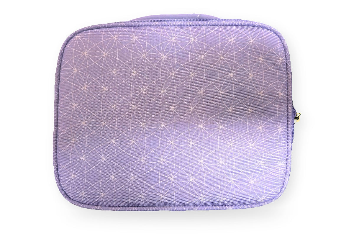 Roots insulated lunch bag in lilac with a white geometric print and teal zippers, back view