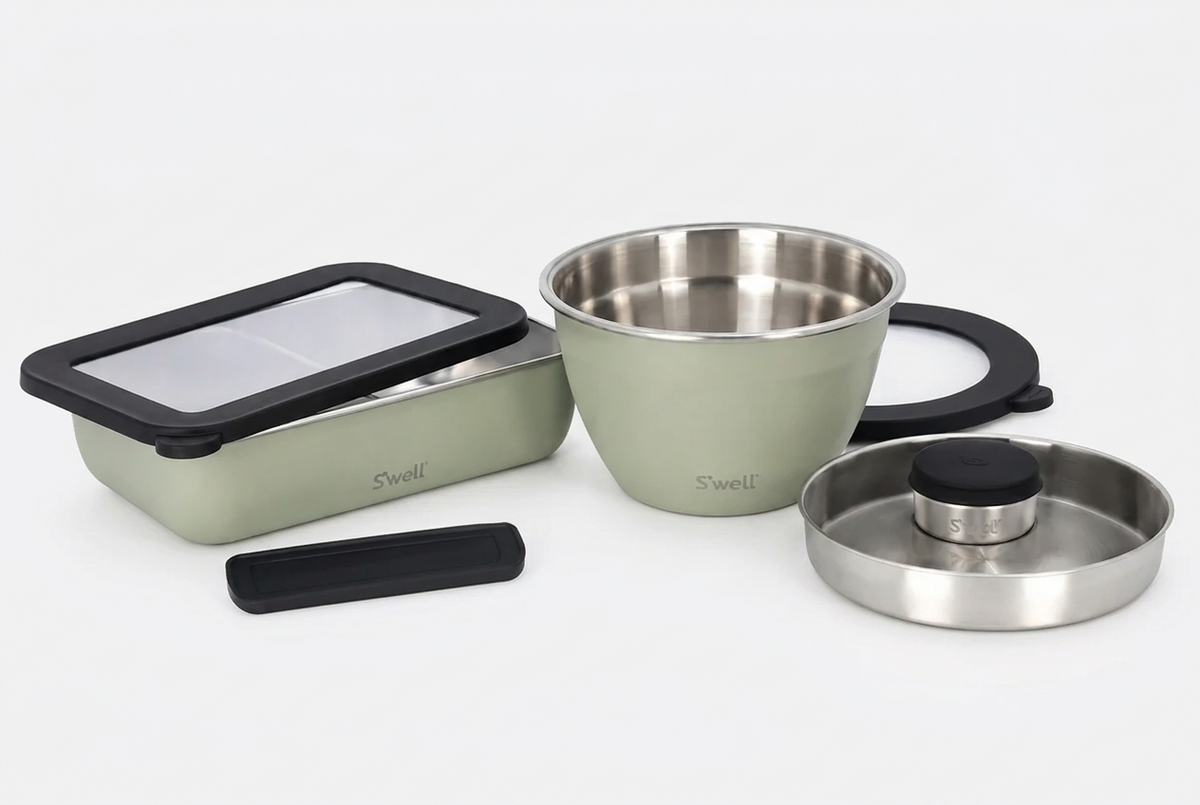 Set of stainless steel containers with lids on a white background