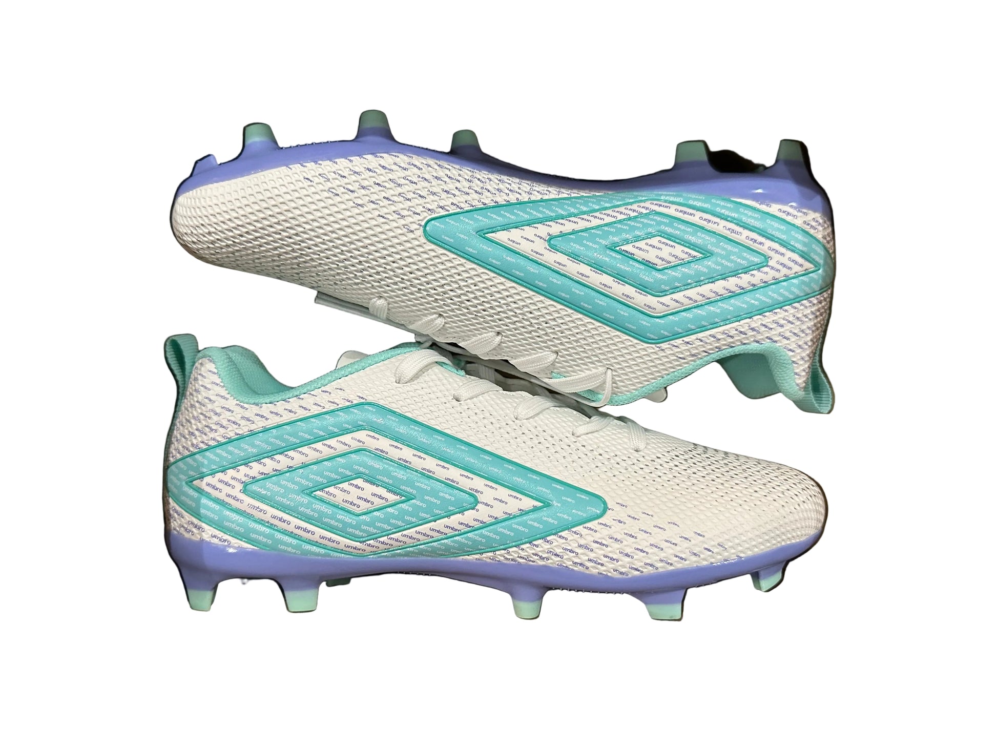 White and blue soccer cleats in a cardboard box on a black speckled surface